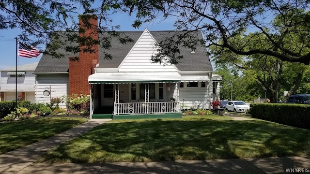 rear view of property with a yard and covered porch