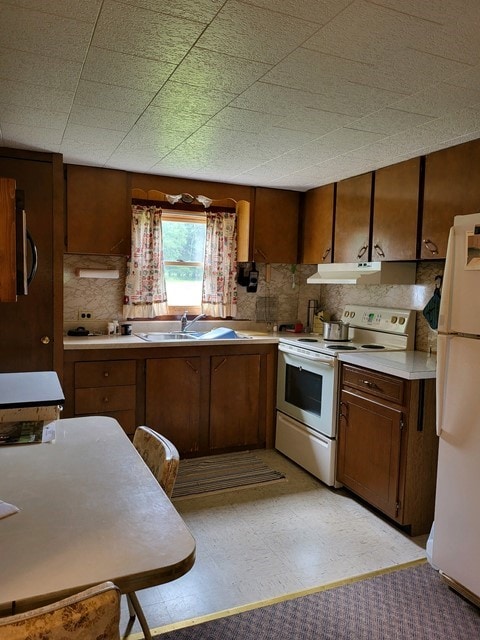 kitchen with sink, white appliances, backsplash, and light tile patterned floors