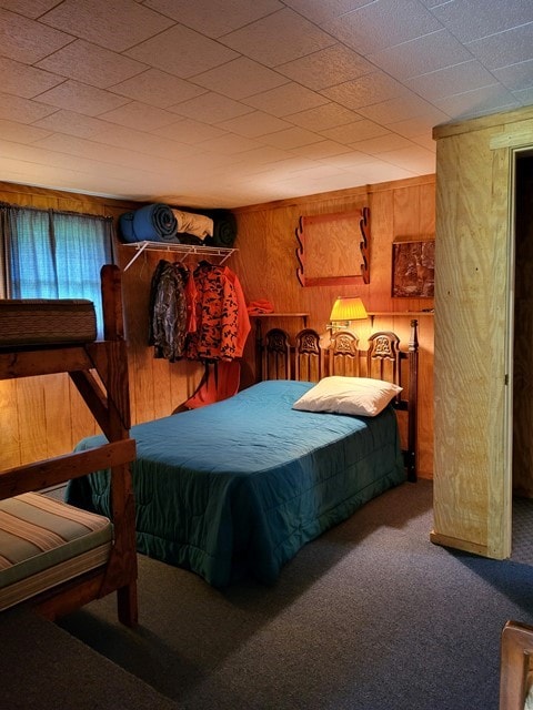 bedroom featuring carpet floors and wooden walls