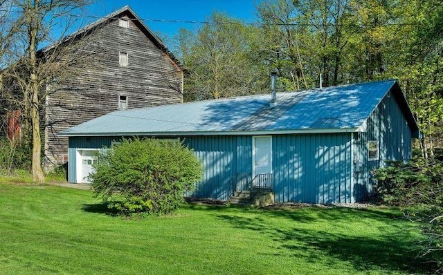 rear view of property with a garage and a lawn