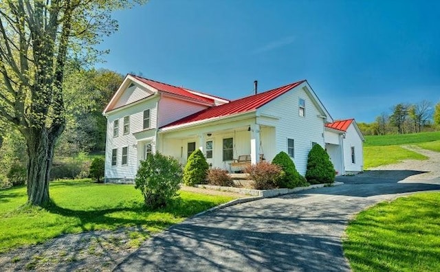 view of property exterior with a porch and a yard