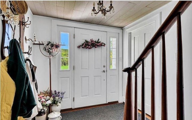 entrance foyer featuring wood ceiling and carpet