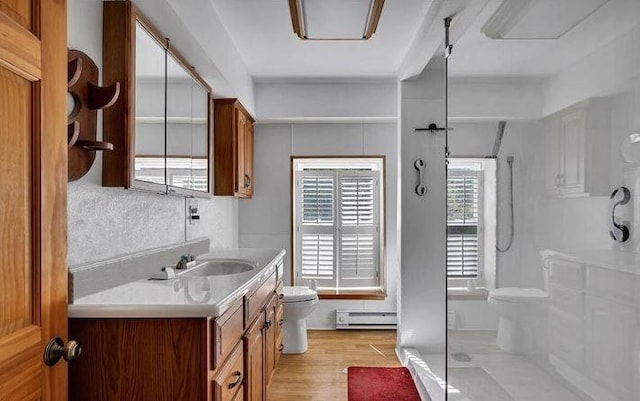 kitchen featuring baseboard heating, sink, and light wood-type flooring