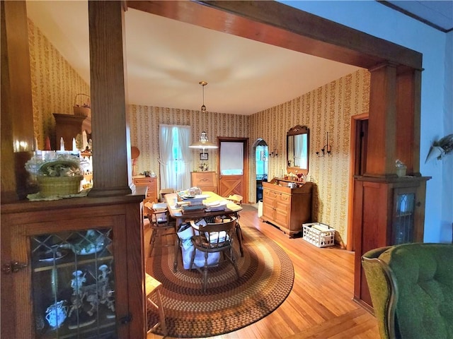 dining room featuring hardwood / wood-style floors and ornate columns