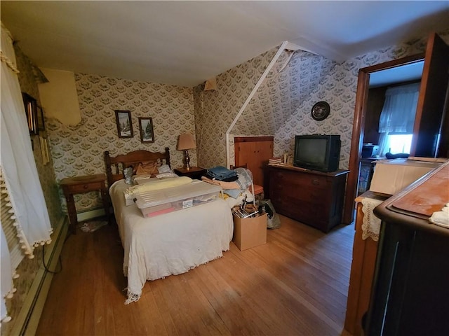 bedroom with wood-type flooring and baseboard heating