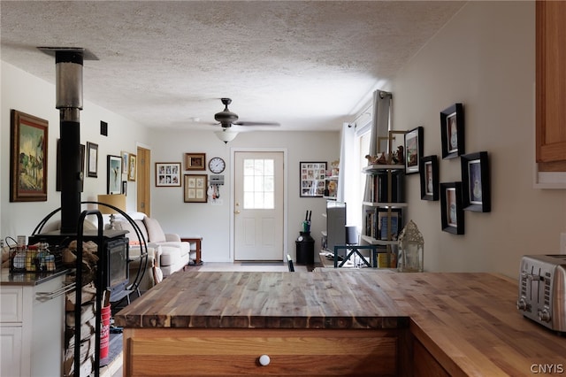 foyer entrance with ceiling fan and a textured ceiling