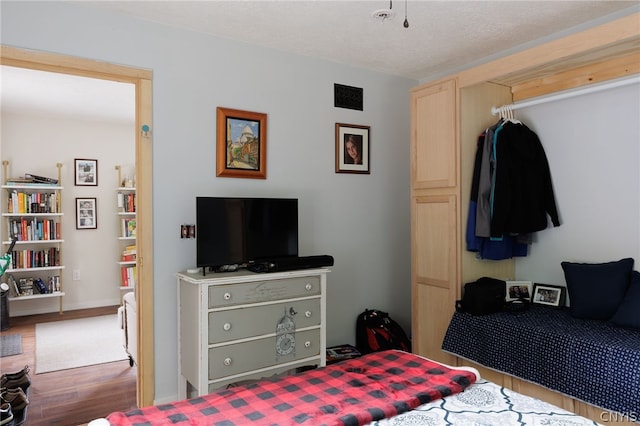 bedroom featuring hardwood / wood-style flooring and a textured ceiling