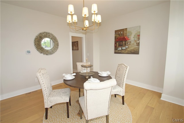 dining room featuring light hardwood / wood-style floors and a notable chandelier