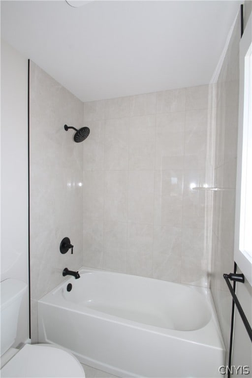 bathroom with toilet and tiled shower / bath combo