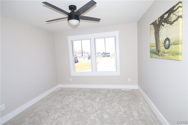 spare room featuring light carpet and ceiling fan