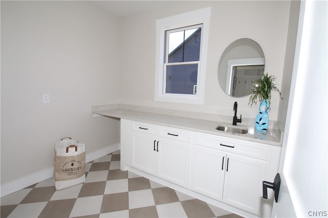 interior space featuring sink and white cabinetry