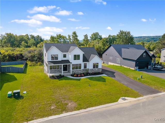 view of front of house with covered porch, a garage, and a front lawn