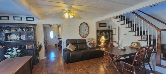 living room with hardwood / wood-style flooring, a textured ceiling, and ceiling fan