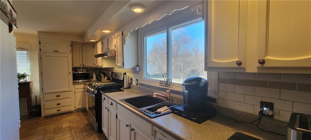 kitchen featuring decorative backsplash, appliances with stainless steel finishes, and white cabinets