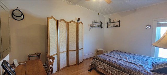 bedroom with crown molding, light wood-type flooring, and ceiling fan