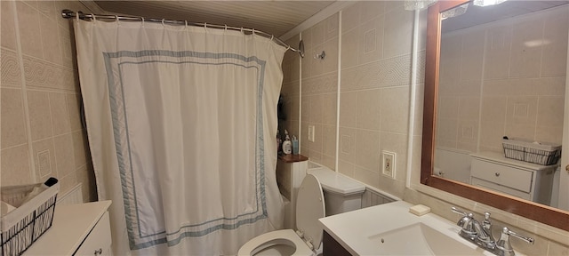 bathroom with vanity, toilet, and tile walls