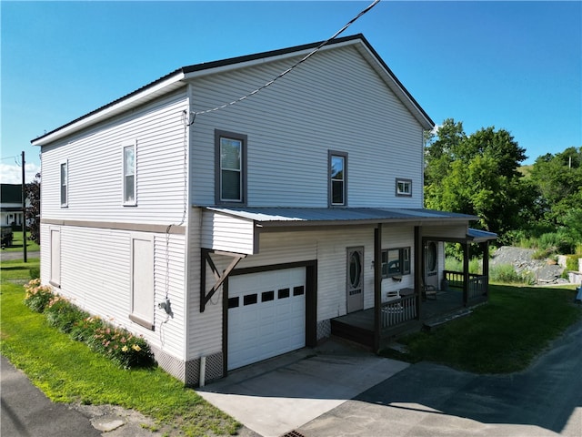 exterior space with covered porch, a garage, and a yard