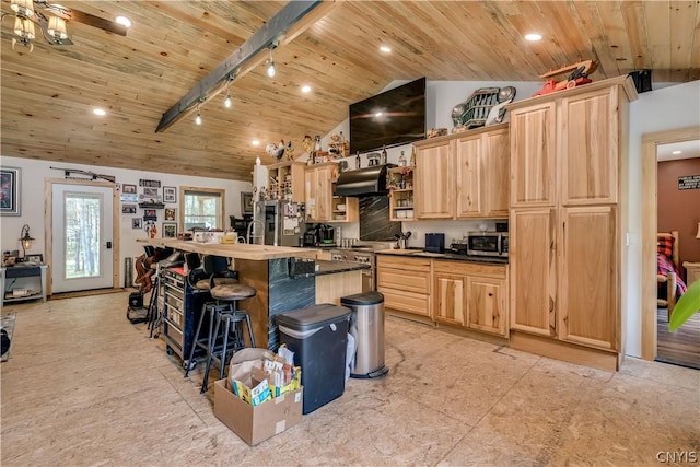 kitchen with appliances with stainless steel finishes, a breakfast bar, a kitchen island, and light brown cabinets