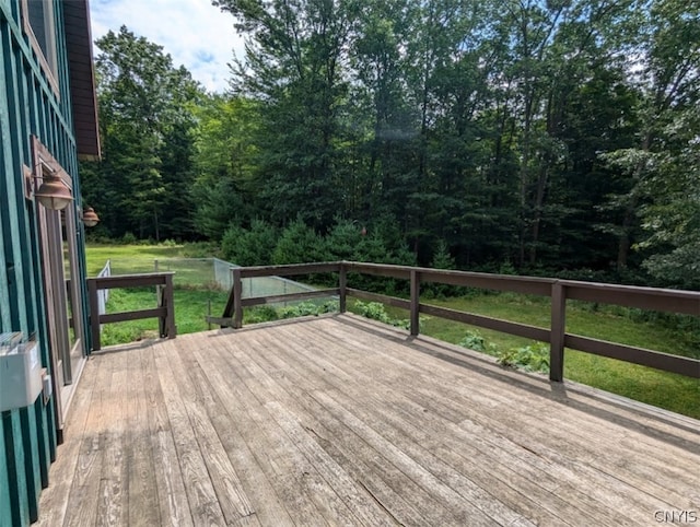 wooden deck featuring a lawn