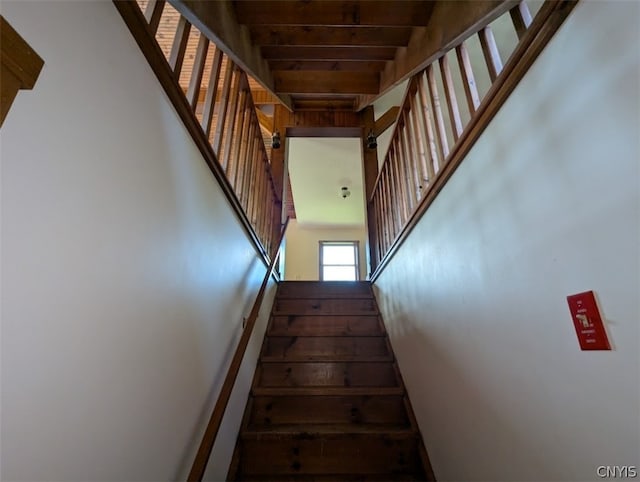 stairs featuring beamed ceiling and wood ceiling