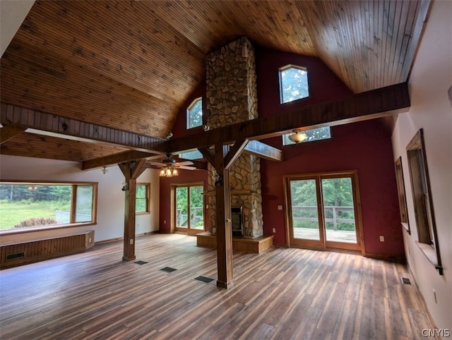 interior space featuring hardwood / wood-style floors, a stone fireplace, high vaulted ceiling, and wood ceiling