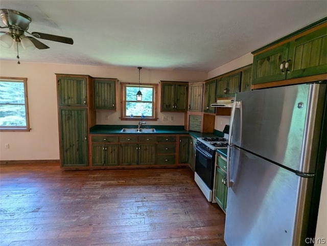 kitchen with stainless steel refrigerator, dark wood-type flooring, ceiling fan, white gas stove, and sink