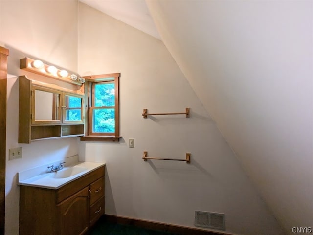 bathroom with vanity and vaulted ceiling