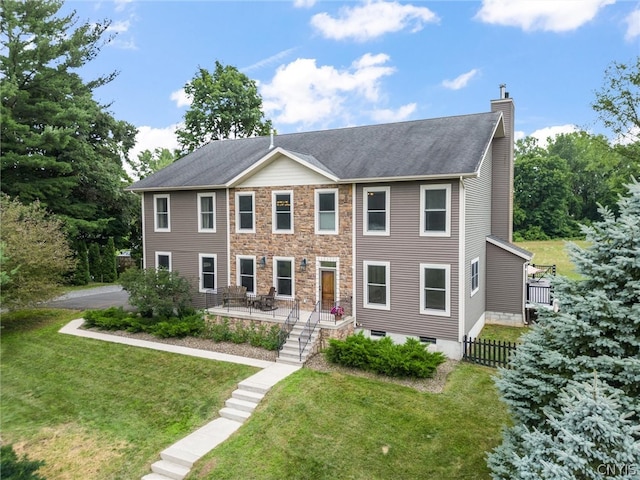 colonial inspired home featuring a patio and a front yard