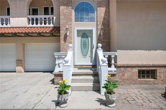 entrance to property featuring a balcony and a garage