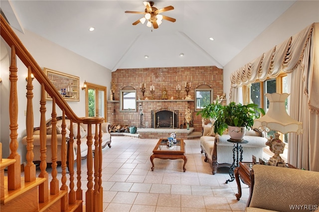 living room featuring ceiling fan, vaulted ceiling, a fireplace, and light tile patterned floors