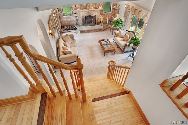 stairs featuring a brick fireplace