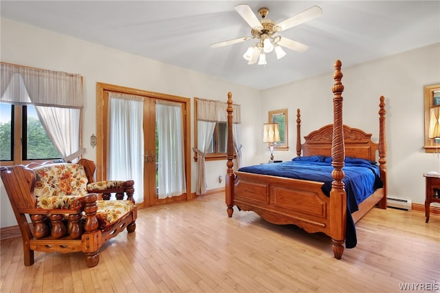 bedroom featuring a baseboard heating unit, ceiling fan, and light hardwood / wood-style floors