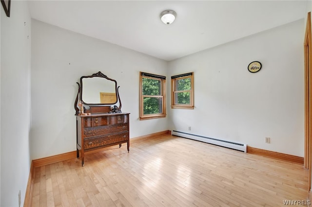 unfurnished room with light wood-type flooring and a baseboard radiator