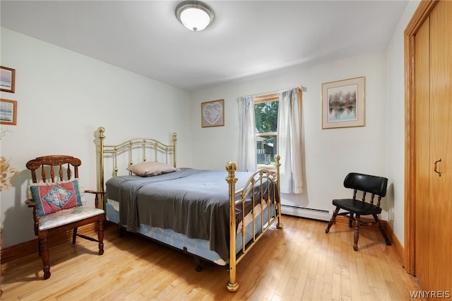 bedroom with light hardwood / wood-style floors and baseboard heating