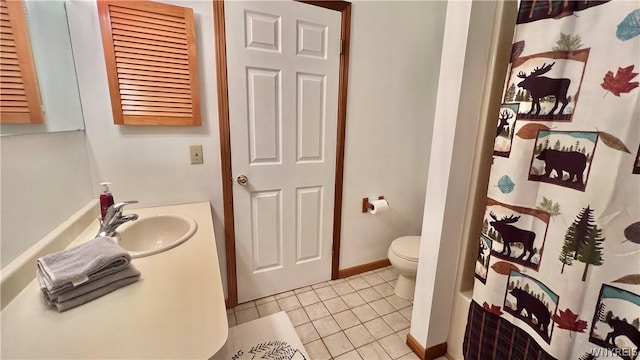 full bathroom featuring tile patterned floors, shower / bath combination with curtain, toilet, and sink