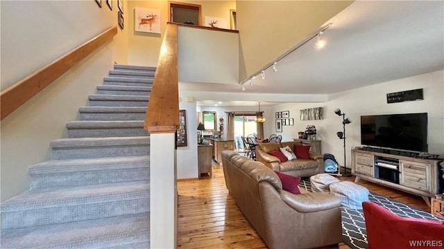 living room featuring a chandelier, track lighting, and light hardwood / wood-style flooring