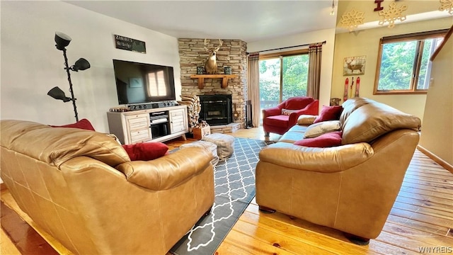 living room featuring a healthy amount of sunlight, a fireplace, and light hardwood / wood-style flooring