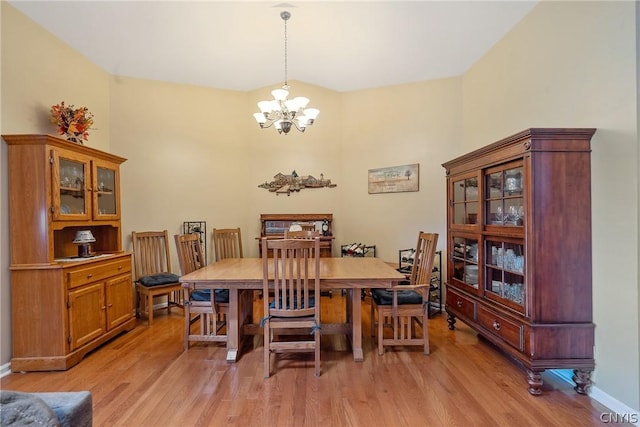 dining space with light hardwood / wood-style floors and a chandelier