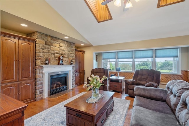 living room with ceiling fan, a healthy amount of sunlight, lofted ceiling, and a fireplace