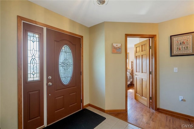 foyer entrance with light wood-style floors and baseboards