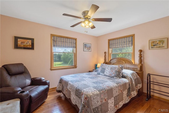 bedroom with hardwood / wood-style flooring, baseboards, and multiple windows