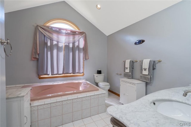 bathroom featuring tile patterned flooring, tiled tub, vaulted ceiling, toilet, and vanity