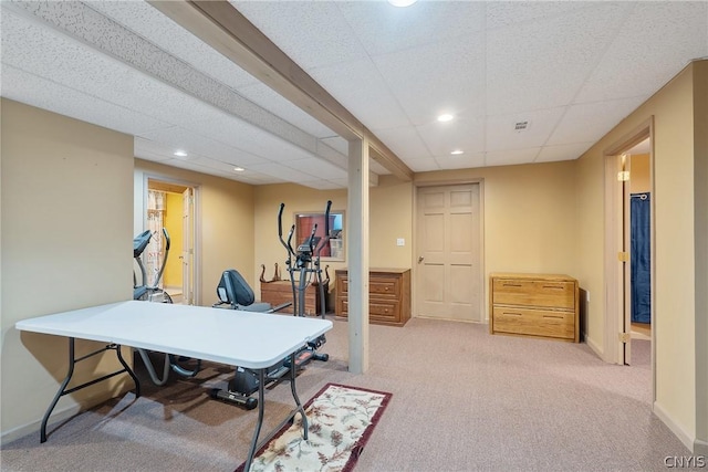 carpeted office space with a paneled ceiling