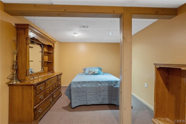 bedroom with carpet floors, a drop ceiling, and visible vents