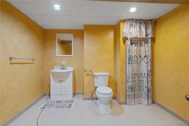 bathroom featuring toilet, vanity, and a paneled ceiling