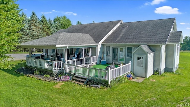 rear view of house featuring a lawn and covered porch