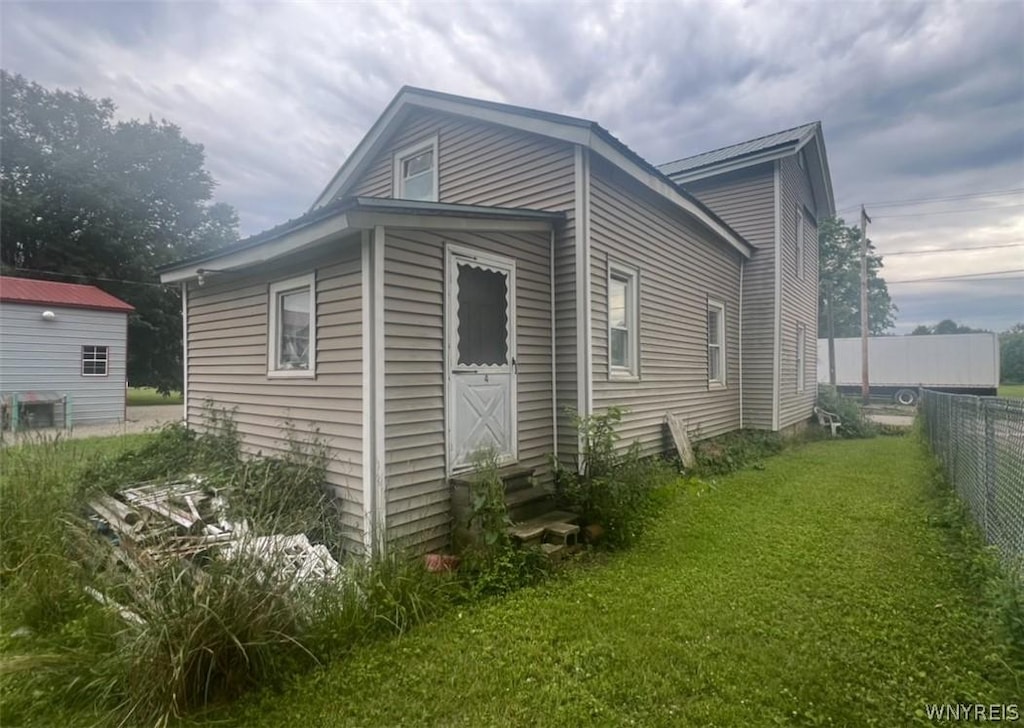 view of side of home with a yard