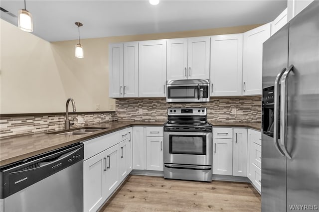 kitchen featuring decorative backsplash, sink, light hardwood / wood-style flooring, and stainless steel appliances