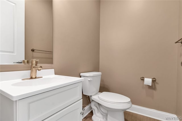 bathroom with hardwood / wood-style flooring, toilet, and vanity