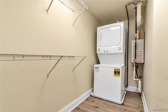 washroom with stacked washer / drying machine and light wood-type flooring